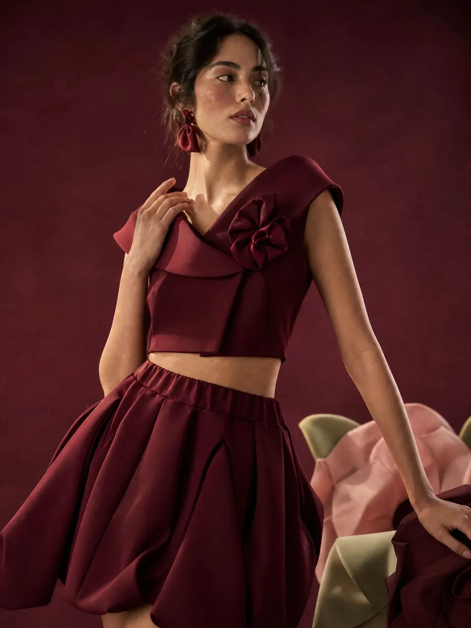 Model in a wine folded-collar crop top and bubble skirt
